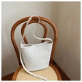 Vue détaillée du sac seau tissé blanc avec texture cuir suspendu sur une chaise en bois - Blanc Cassé