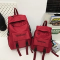 Set di zaini vintage rossi in tela con ricamo di lettere bianche in un ambiente casual - Grande / Rosso