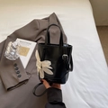 Borsa a secchiello in pelle lucida nera con ciondolo a fiore bianco e dettagli argentati - Nero