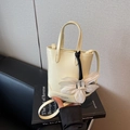 Mini borsa a secchiello minimalista in pelle beige con ciondolo a fiore e tracolla - Giallo