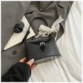 Close-up of woven leather bucket bag with silver buckle and pearl lace charm - Black With Pendant