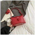 Close-up of red woven leather bucket bag with silver buckle and pearl bow charm - Red with Pendant