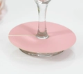 Close-up of pink round place cards for wine glass bases on elegant white table setup - Pink