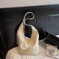 Creamy white pebbled leather hobo bag with round coin purse charm on a white bed - Off-white
