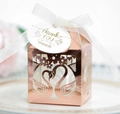 Macro view of rose gold laser-cut swan heart candy box with white silk ribbon and tag - Reflective Rose Gold
