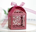 Detail of burgundy laser-cut rose hollow candy box with silk ribbon on white porcelain - Dark Red