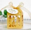Detail of laser-cut gold wedding favor box with bride and groom silhouette and ribbon - Gold
