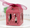 Close-up of red laser-cut candy box featuring bride and groom silhouettes and ribbon - Dark Red