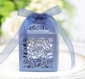 Close-up of laser-cut blue wedding favor box with rose patterns and matching ribbon - Royal Blue