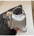 Gros plan du sac seau argenté en cuir texturé litchi avec un pendentif coloré chic - Avec Pendentif / Argent