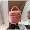 Pink quilted mini bucket bag with gold chain strap and heart charm in a soft setup - Pink
