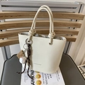 Creamy white litchi leather bucket bag with knot handle and baseball charm detail - With Pendant / White