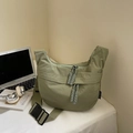 Detail of sage green nylon crescent bag with woven rope zipper and black buckle - Large / Green