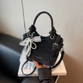 Elegant black velvet bucket bag featuring white lace bow and pearl chain details - Black