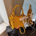 Chic yellow suede bucket bag with decorative pearl and lace bow charm on handle - Yellow