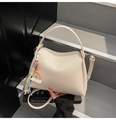 Sac seau minimaliste beige en cuir grainé avec pompon arc-en-ciel sur un escalier élégant - Avec Pendentif / Blanc
