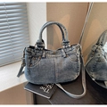 Detalle de bolso vaquero azul lavado vintage con remaches metálicos y bolsillos - Azul Denim