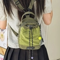 Olive green drawstring crossbody bag with mesh detail worn by a model outdoors - With Charm / Green