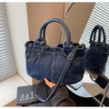 Vista detallada del bolso tote de mezclilla azul oscuro con tachuelas de latón vintage y costuras - Azul oscuro