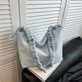 Chic light blue pleated shoulder bag with metallic logo on a stylish indoor setting - Blue Without Charm