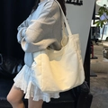 Borsa tote in tela bianco sporco con stampa grafica blu indossata sulla spalla del modello - Bianco Sporco