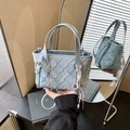Light blue denim tote bag with quilted texture and crossbody strap in mirror reflection - Blue with Charm