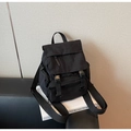Close-up of black nylon backpack with flap closure and multiple zipper pockets - Black
