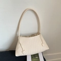 Dettaglio della trama intrecciata crema e del cordoncino sulla borsa a spalla da donna - Bianco