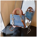 Blue denim crossbody handbag with brown leather handles and a pearl bow pendant - With Charm / Denim Blue