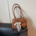 Brown patent leather bowling bag with heart pockets and pearl bow charms detail - Brown