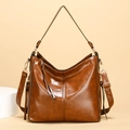 Retro brown leather bucket bag with wide shoulder strap and gold hardware accents - Caramel color