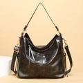 Polished black hobo bucket bag with gold hardware and adjustable wide shoulder strap - Black