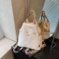 Off-white nylon backpack with colorful woven straps on a book background - Off White