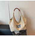 Détail du sac cabas en toile avec broderie bleue et anses en cuir marron - Kaki
