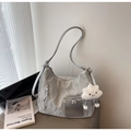 Detail of silver metallic dumpling bag featuring a soft cloud pendant in a modern setting - Silver