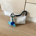 Chic cream woven shoulder bag with black leather handle and blue elephant charm accessory - Off-white (With Pendant)