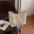 Cream woven shoulder bag with adjustable strap and textured finish in a lifestyle setting - Off White