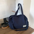 Detail der dunkelblauen Canvas-Tasche mit verstellbarem Schultergurt und Markenetikett - Marineblau