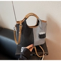 Vue détaillée du sac en toile denim bicolore avec poignées en cuir brun et mini breloque - Noir