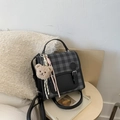 Close-up of checkered crossbody bag featuring a metal buckle and cute brown bear pendant - With Charm / Black