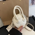 Minimalist white circular crossbody bag with lychee texture and heart-shaped handle connectors - Off White