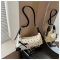 Detail of cream shoulder bag with black bow patterns and textured embossed fabric - White