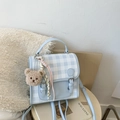 Detail of light blue plaid backpack featuring PU leather texture and a cute bear charm - With Charm / Blue