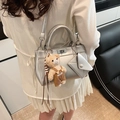 Silver metallic crossbody bag with envelope pouch and teddy bear charm on model - Silver (With Pendant)