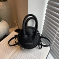 Mini round black pebbled leather crossbody bag with silver star logo and top handles - Black