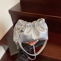 Elegante bolso nube plateado con cadena metálica y colgante de esfera sobre fondo madera - Plateado