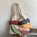 Chic cream knit crochet tote bag paired with colorful fish-shaped fabric charms - White