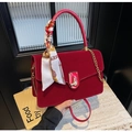Detail of red velvet handbag featuring gold clasp and decorative floral silk scarf - Red