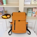 Mustard yellow backpack with rectangle flap and vertical front zipper in school setting - Brown