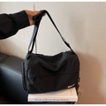 Macro view of black nylon crossbody bag featuring dual zippers and branded BNT logo detail - Black